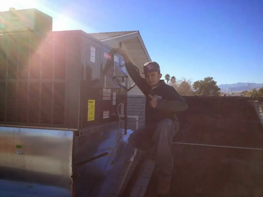 HVAC technician performing Boiler Repair on a rooftop unit in Wyldwood
